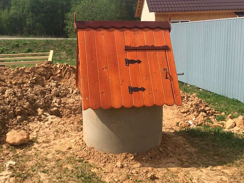Колодец с оранжевым домиком на участке